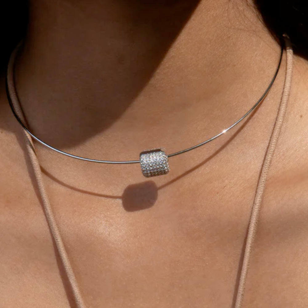 Silver charm on necklace on model