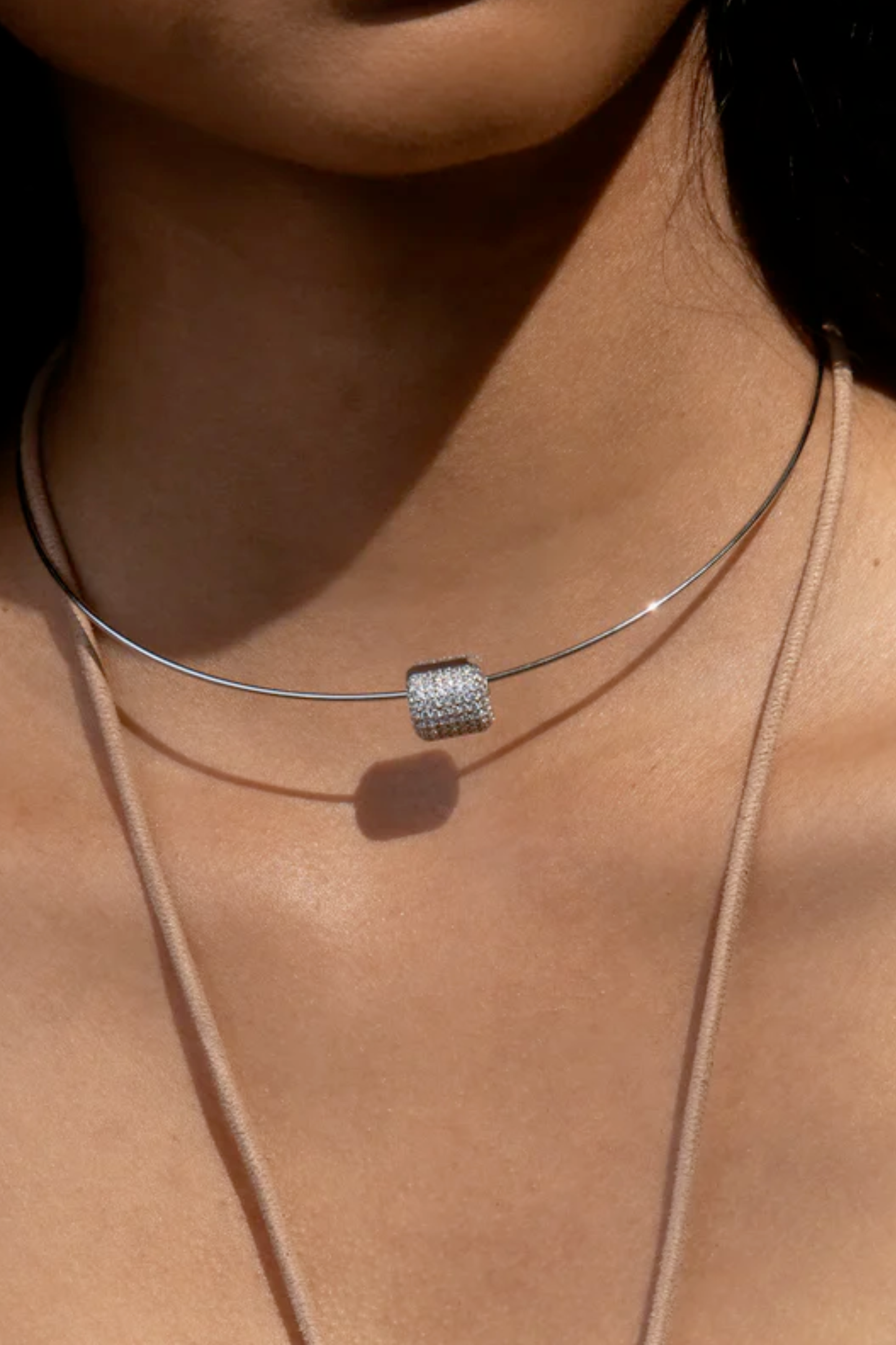 Silver charm on necklace on model