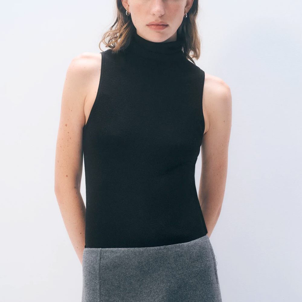 Model wearing a sleeveless black turtleneck from White & Warren